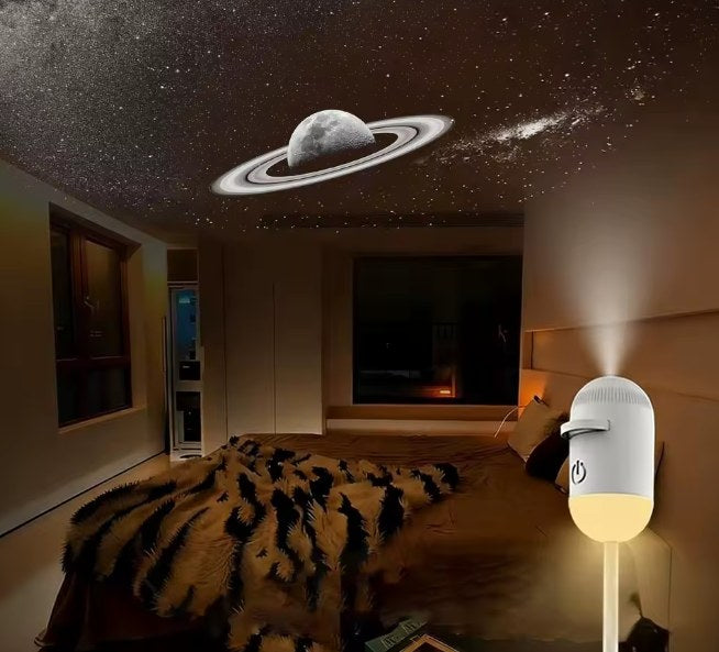 Saturn and stars projected on a bedroom ceiling, the Astrio projector glowing warmly by the bed